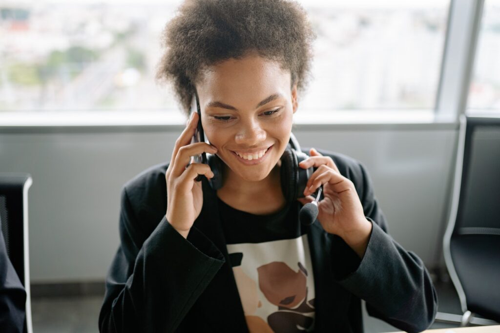 A woman smiling while talking on a cell phone