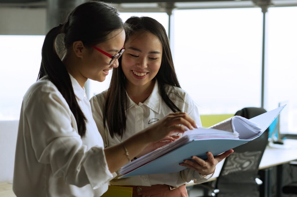 Two girls looking at an outsourcing strategy document