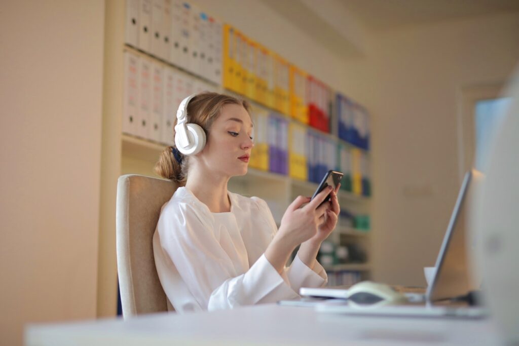 A girl with headphones browsing on her mobile phone