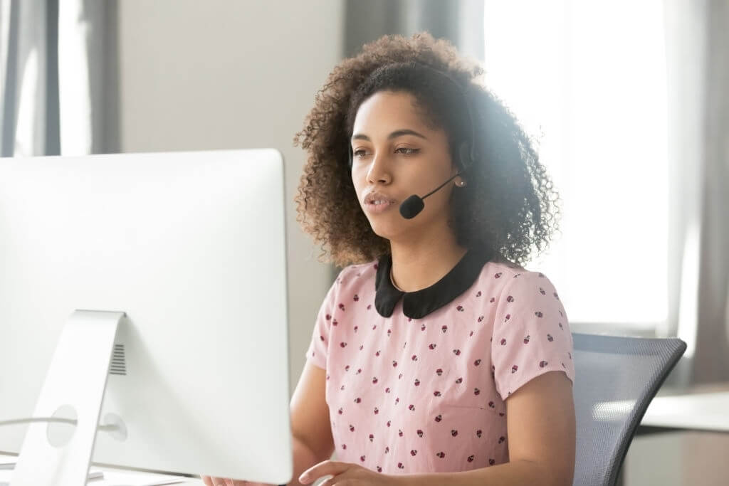 A female contact center agent with headset at her workplace