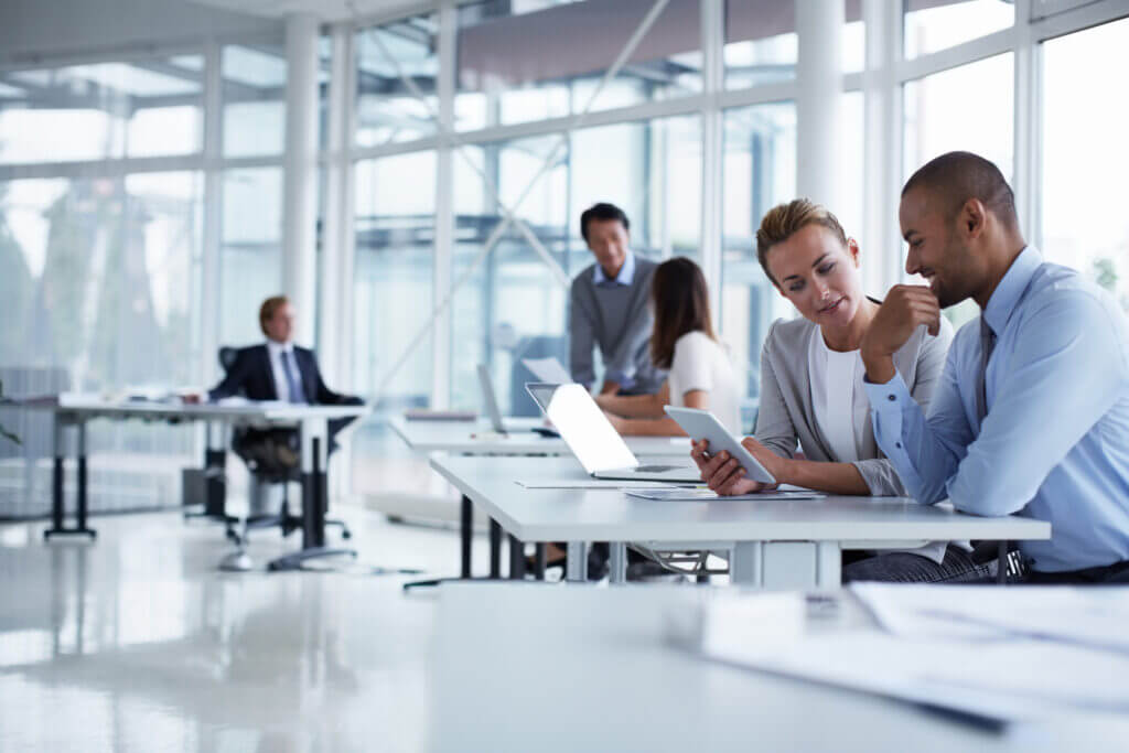 Business colleagues discussing over digital tablet at desk in office