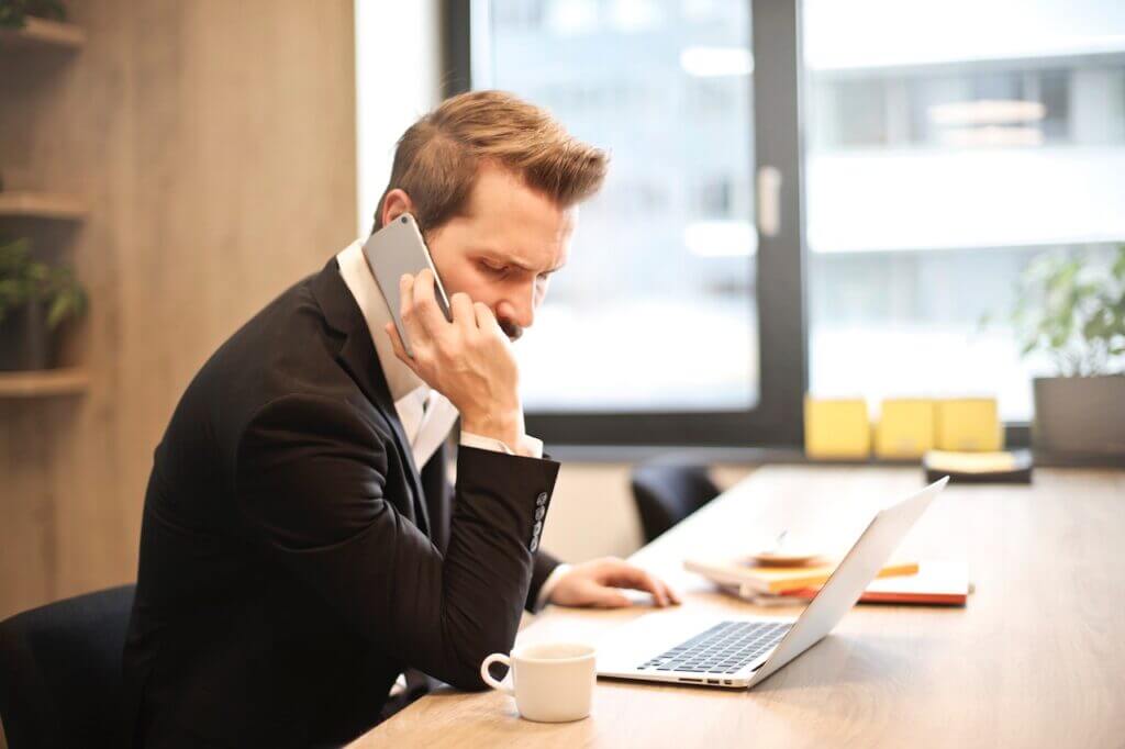 Man Having a phone call In front of a laptop in a contact center