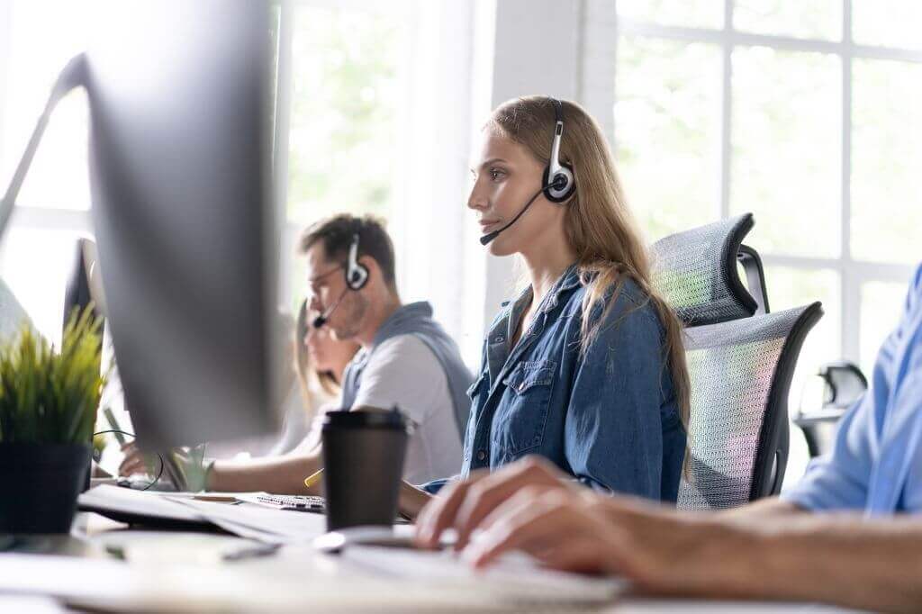 Agents wearing headsets working n a busy contact center