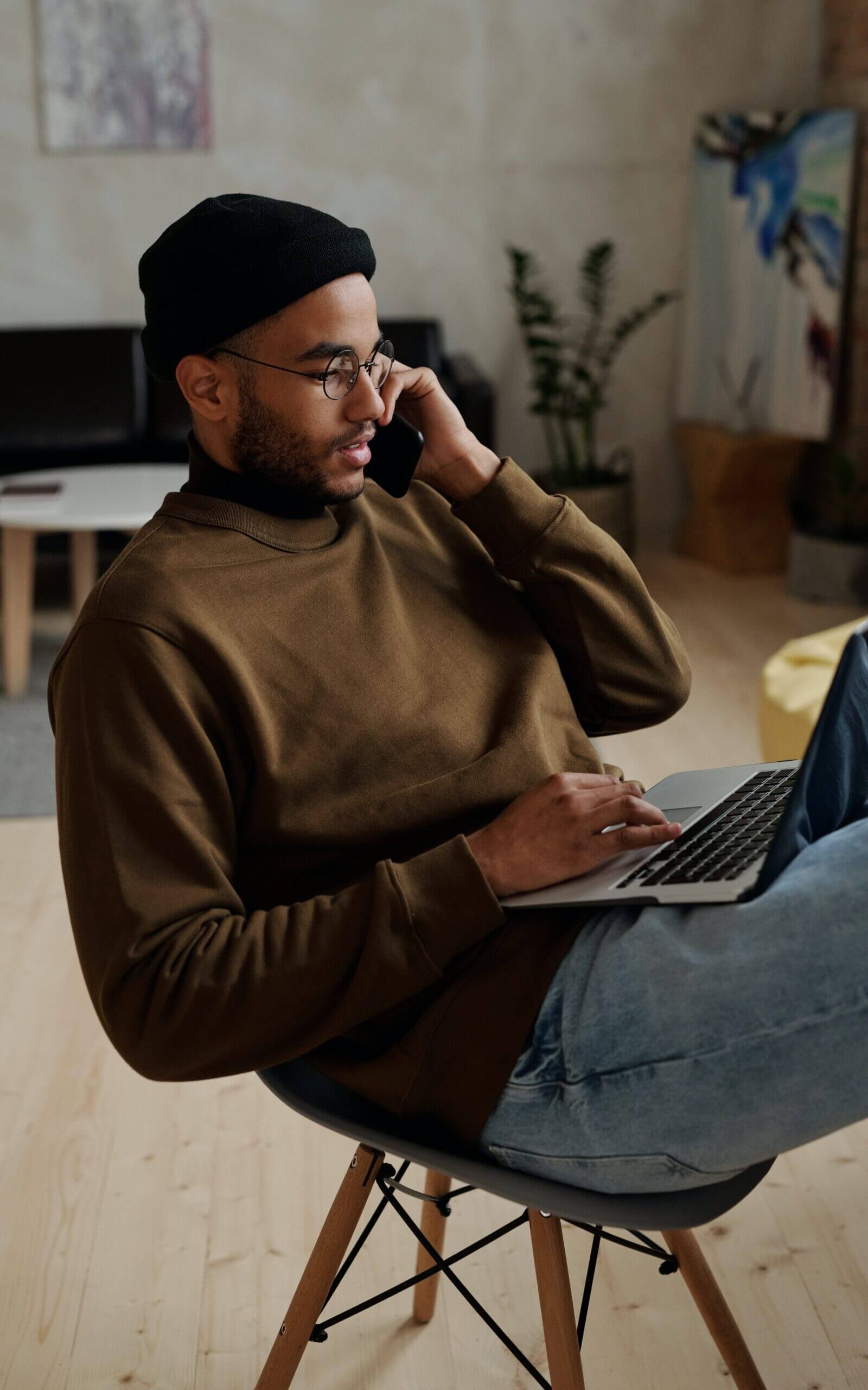 Man talking on the phone while working on a laptop