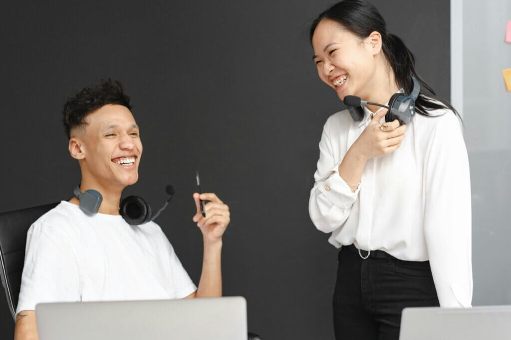 Laughing Man and Woman Working in a Call Center