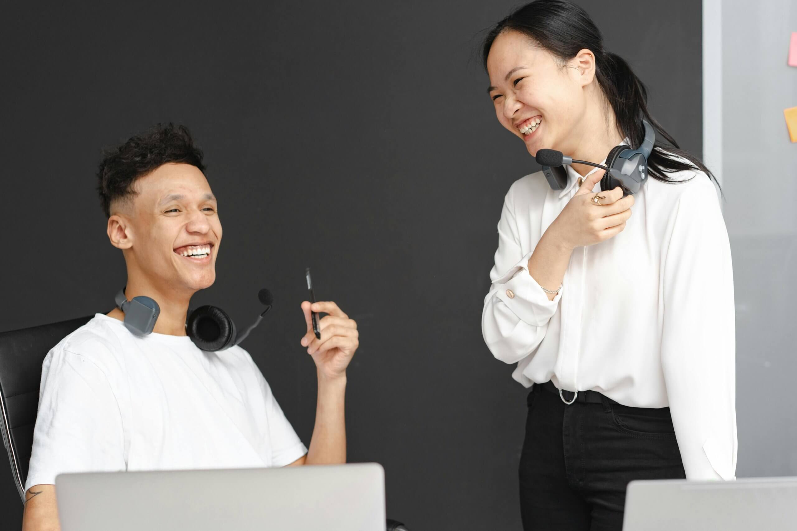 Laughing Man and Woman Working in a Call Center