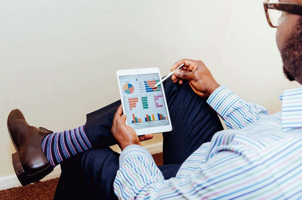 Man Wearing White and Blue Pinstriped Dress Shirt Holding White Ipad